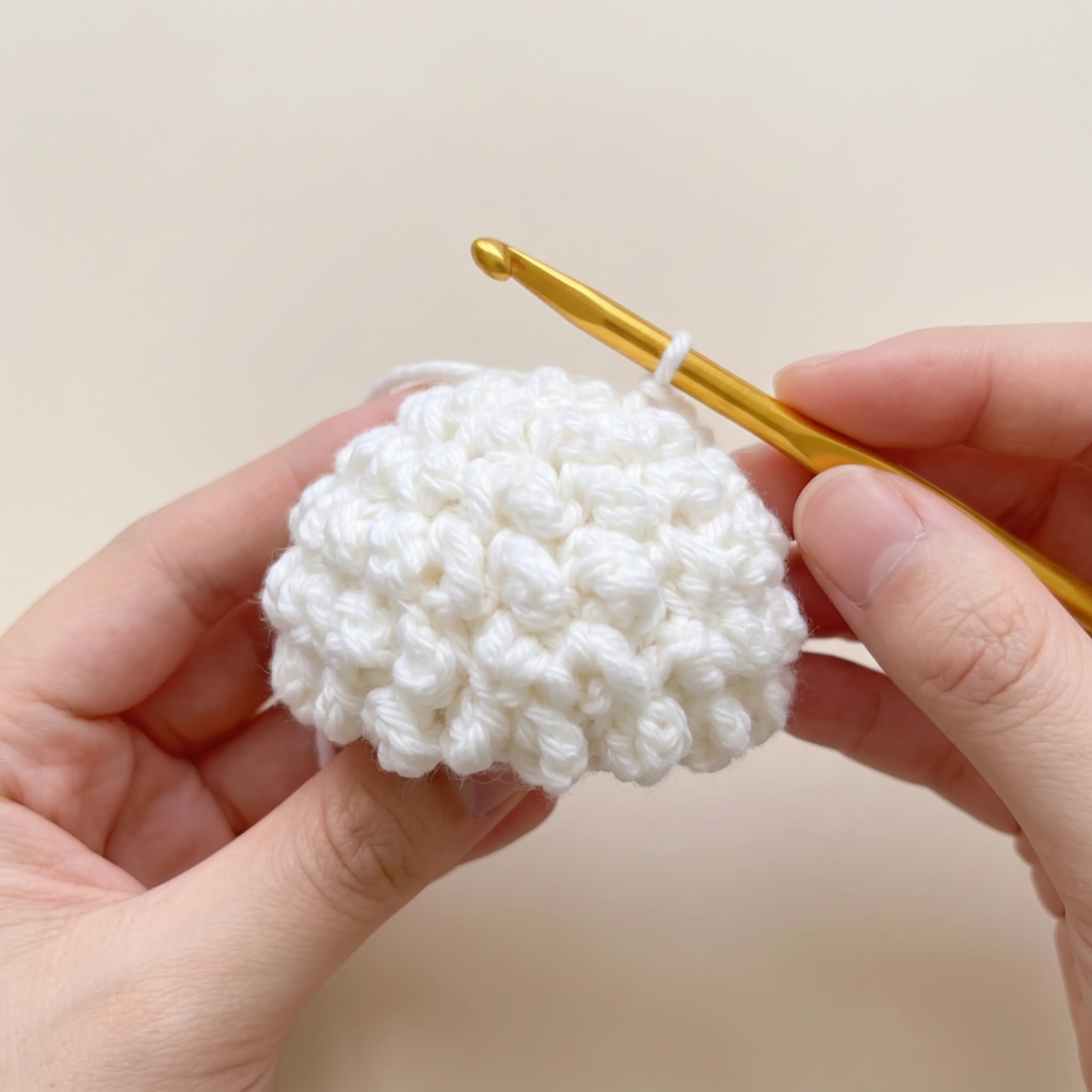 The finished loop stitch wool cap piece for the crochet lamb keychain, before attaching