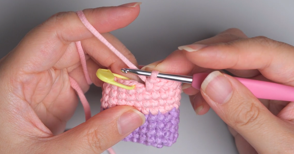 Pulling the new yarn color through the last stitch of the previous color on a crochet project